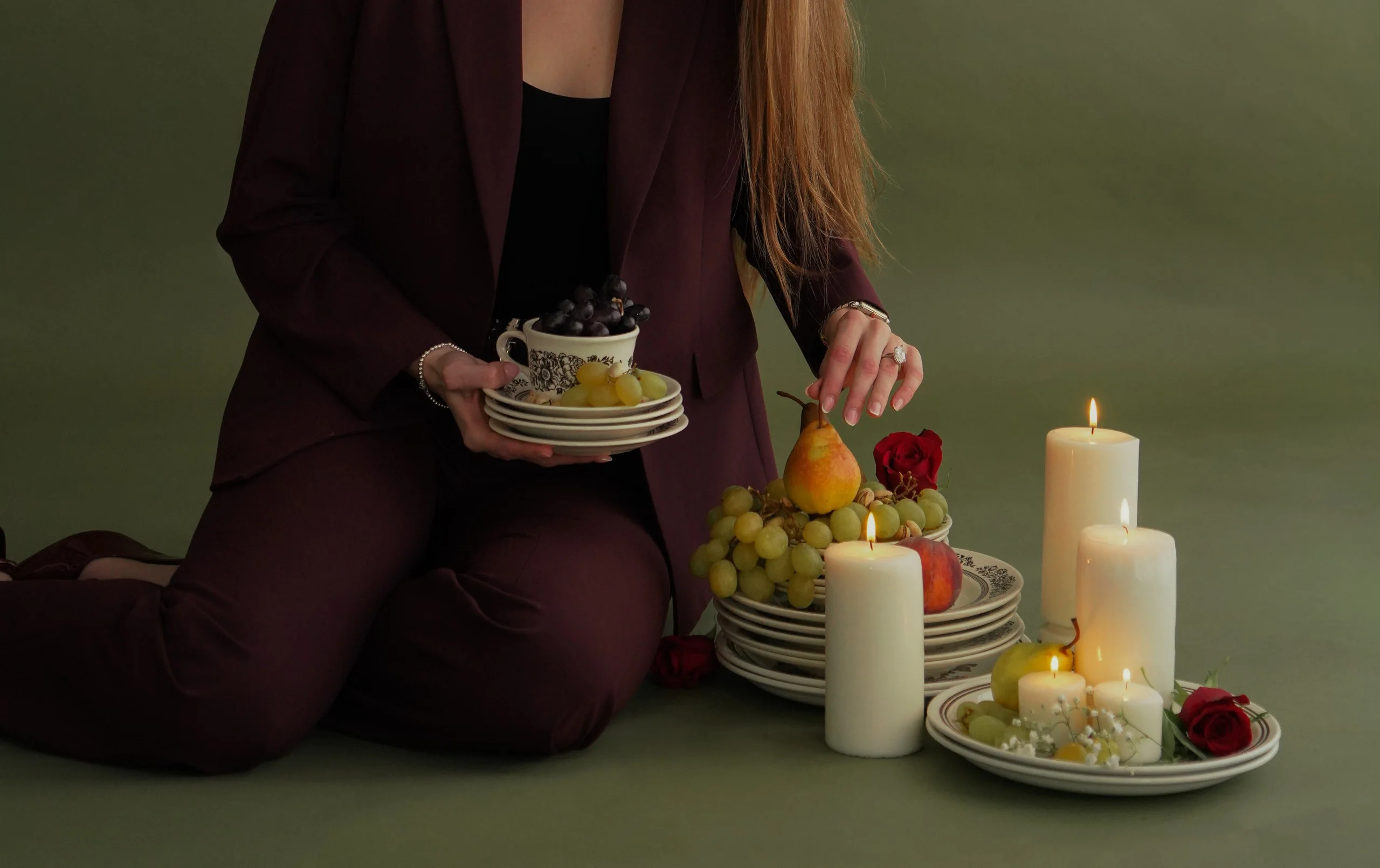 Table setting with fruit, candles, and stacked plates.
