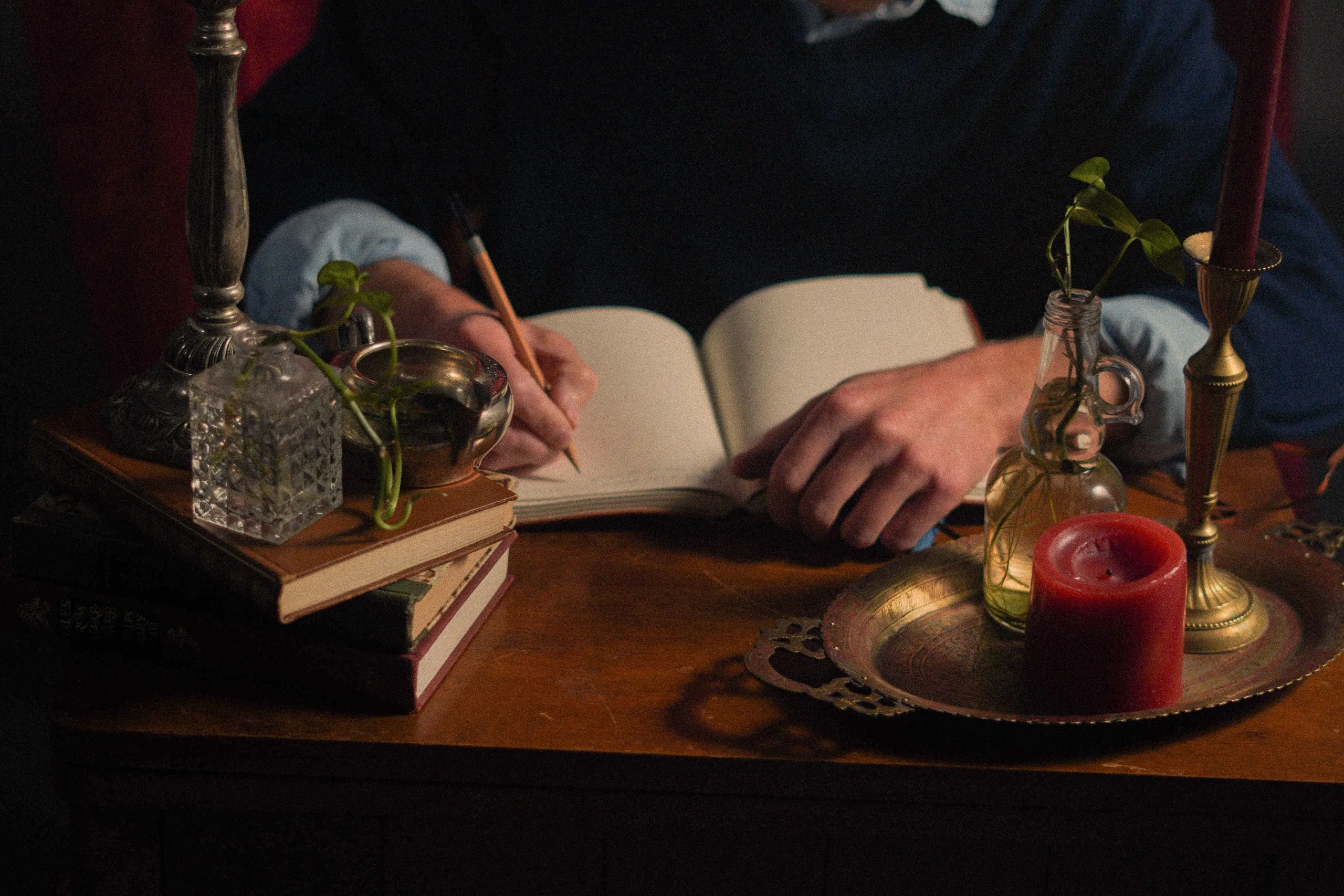 Person writing in a notebook at a desk.